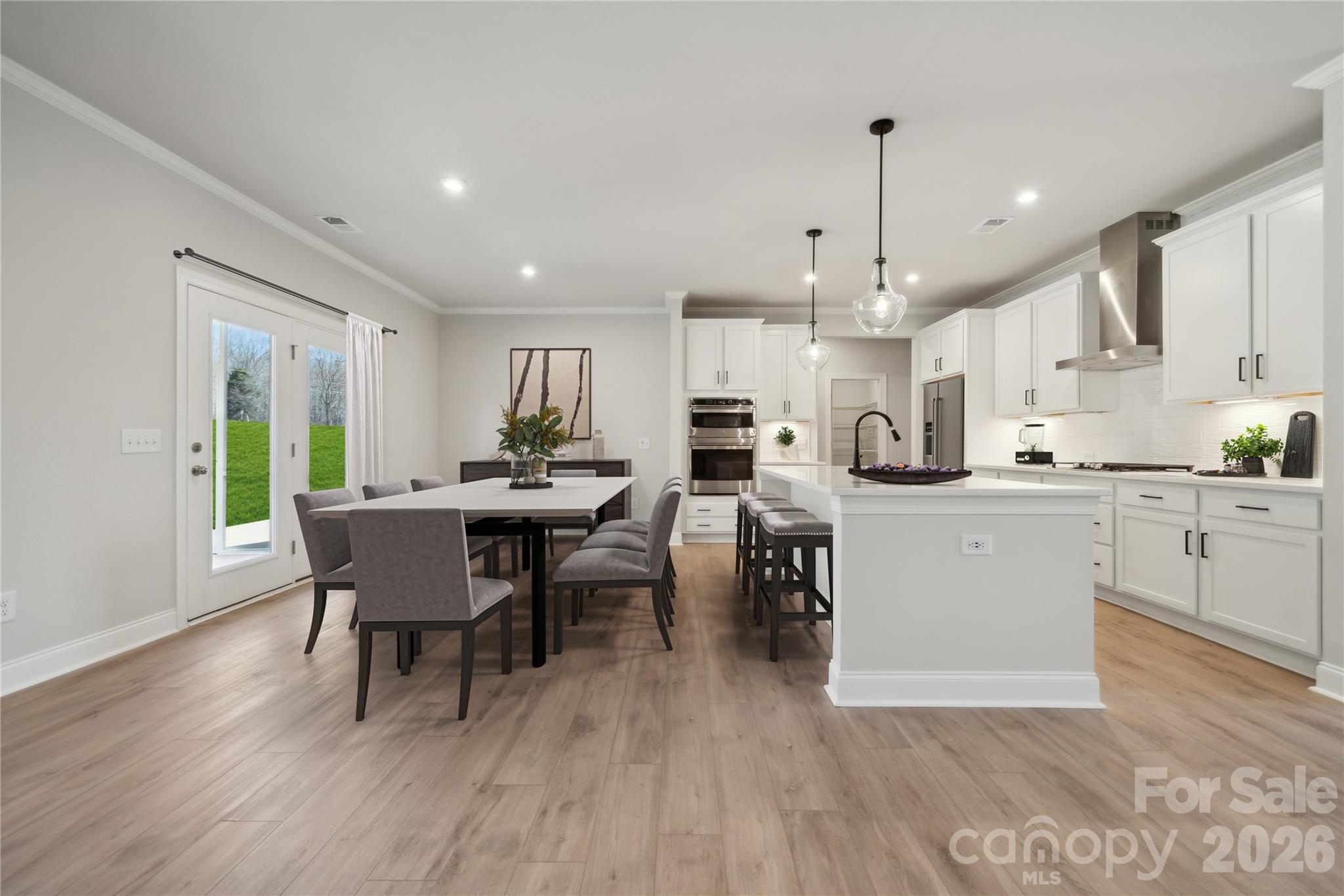 343 Alameda Way Matthews, NC 28104 - Photo 8 of 30 a kitchen with a dining table chairs wooden floor appliances and cabinets