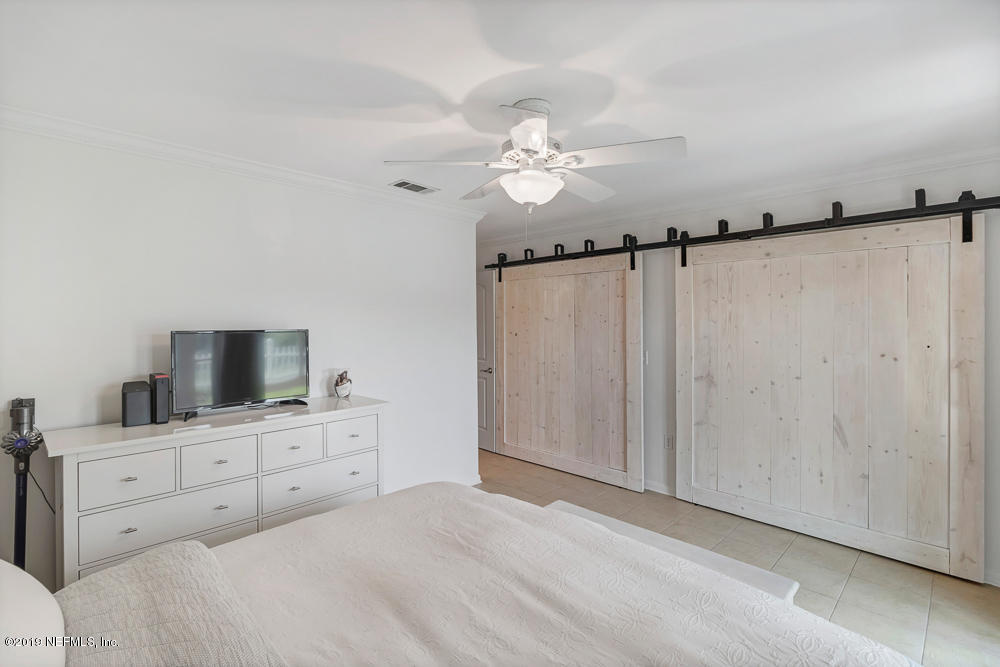 4 Ocean Trace Road, Unit 6 St. Augustine, FL 32080 - Photo 14 of 31 a bedroom with a bed and a flat tv screen on dresser