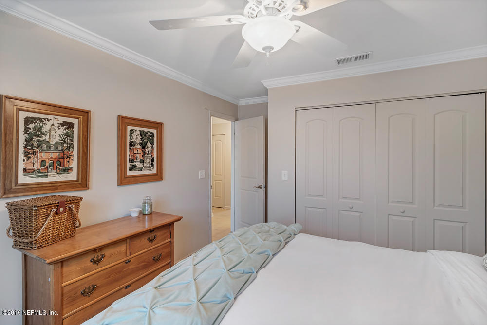 4 Ocean Trace Road, Unit 6 St. Augustine, FL 32080 - Photo 17 of 31 a bedroom with a bed and a chandelier