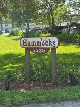 a view of a street sign under a large tree