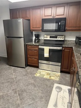 a kitchen with a refrigerator and a stove top oven