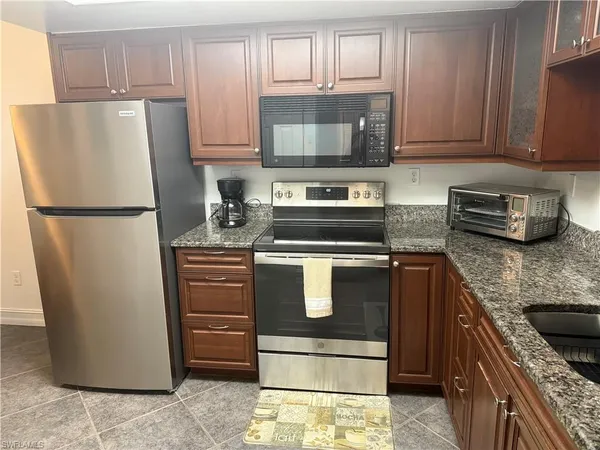 a kitchen with refrigerator a microwave a stove and cabinets