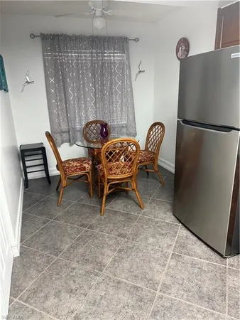 a living room with furniture and a refrigerator