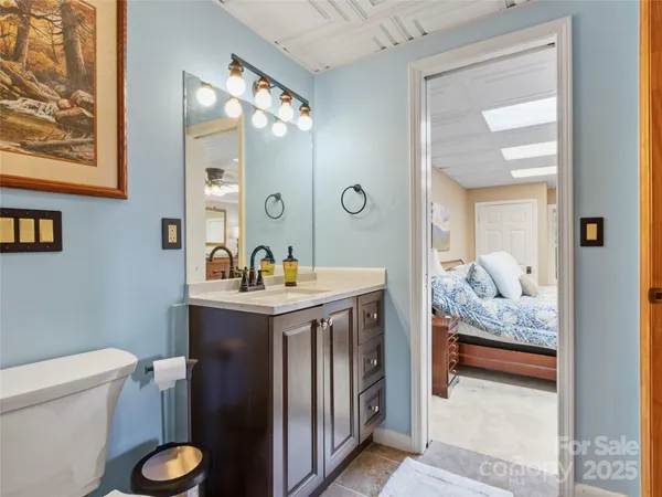 a en suite bathroom with a granite countertop sink and a mirror