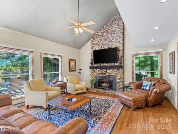 a living room with furniture fireplace and a large window