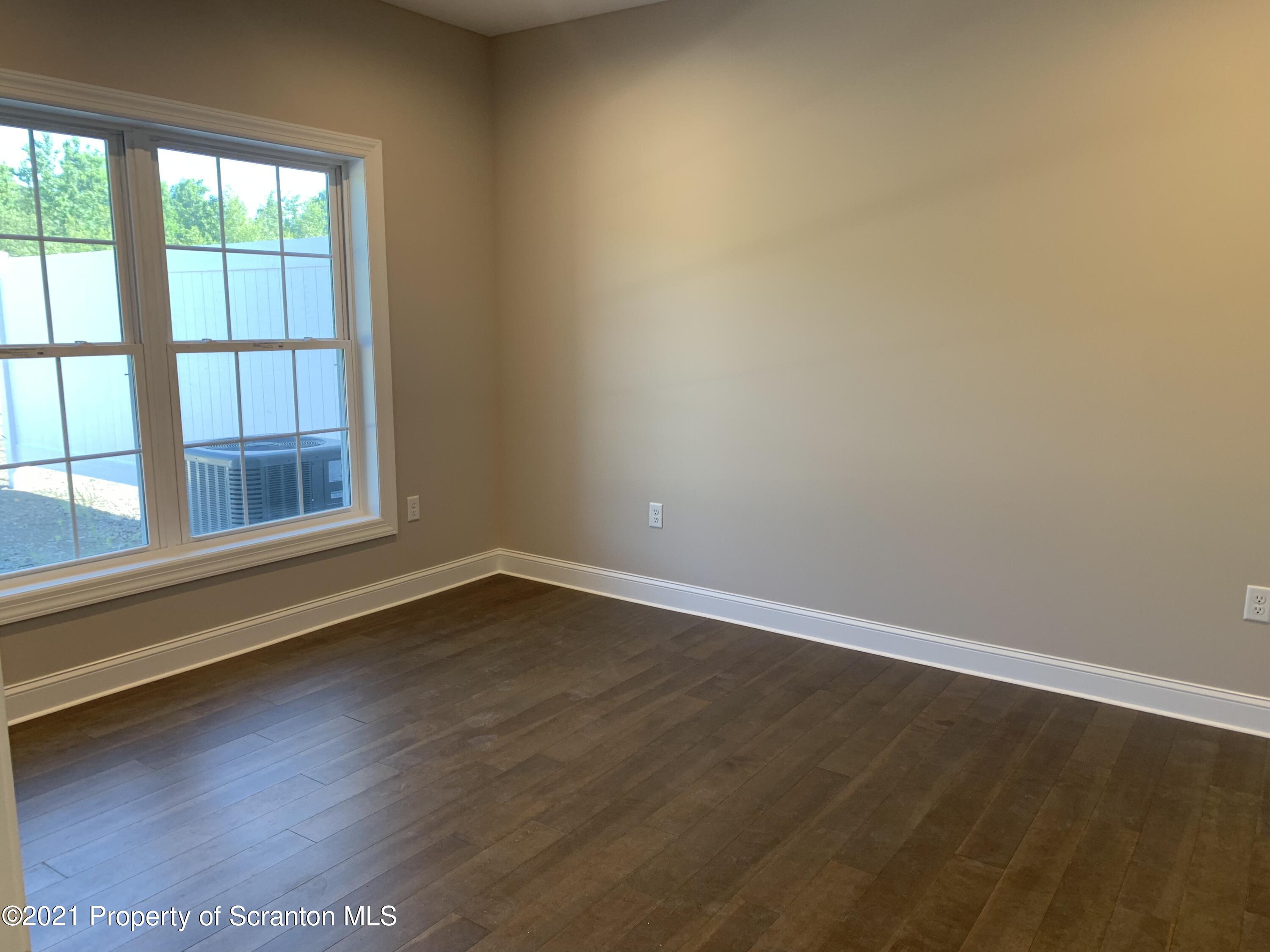 104 Deerfield Drive Eynon, PA 18403 - Photo 14 of 25 a view of an empty room with wooden floor and a window