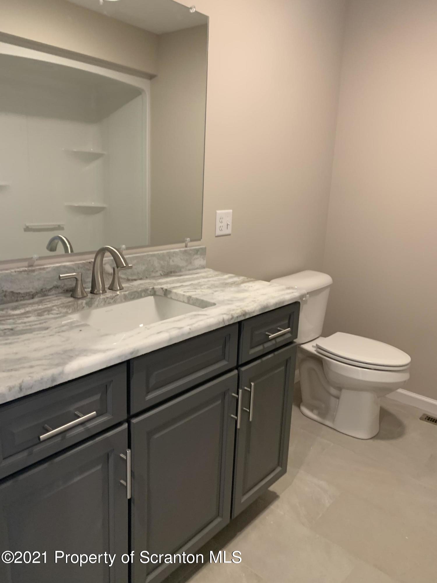 104 Deerfield Drive Eynon, PA 18403 - Photo 22 of 25 a bathroom with a granite countertop sink a toilet and mirror