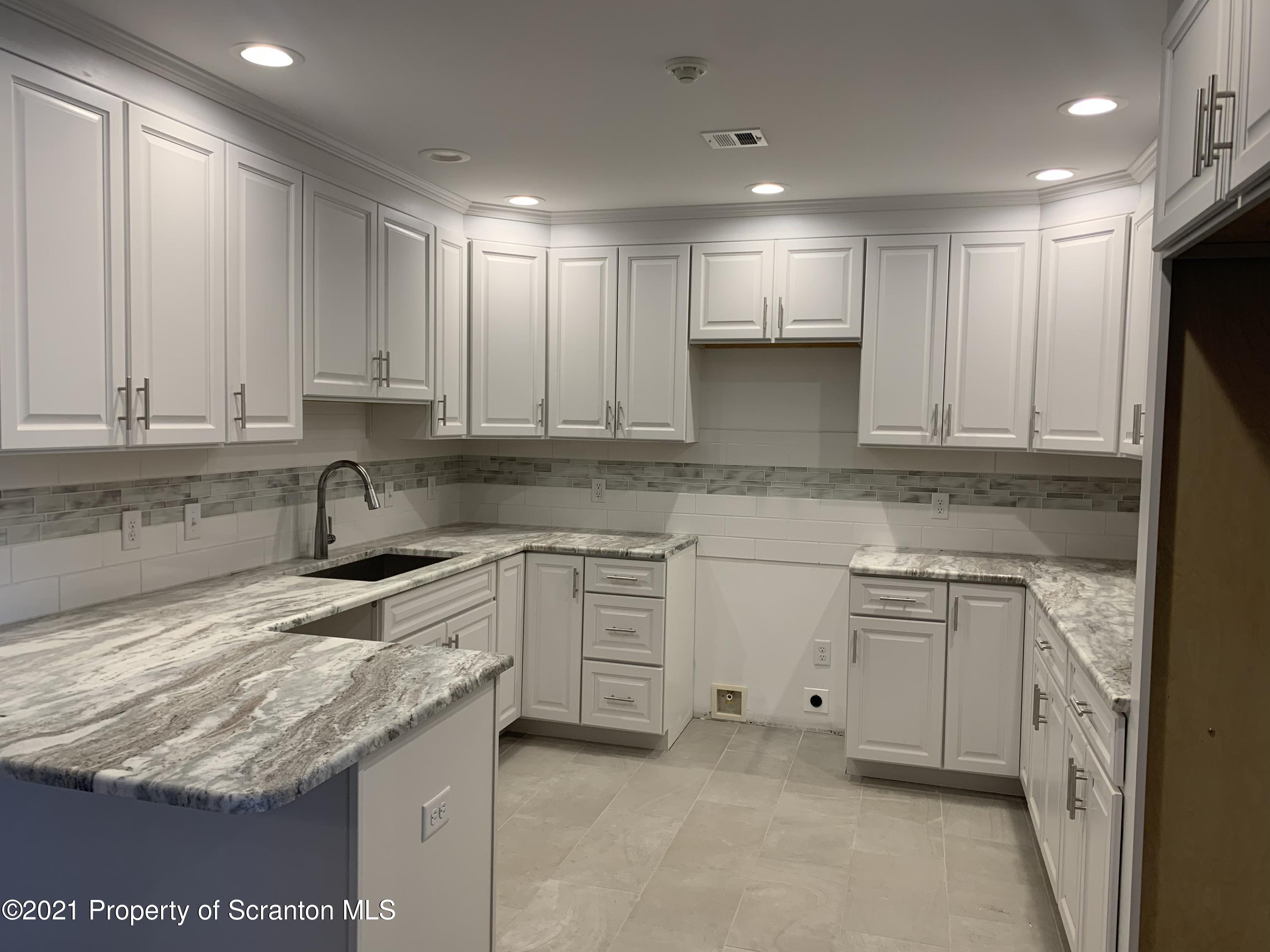 104 Deerfield Drive Eynon, PA 18403 - Photo 3 of 25 a kitchen with granite countertop white cabinets and stainless steel appliances
