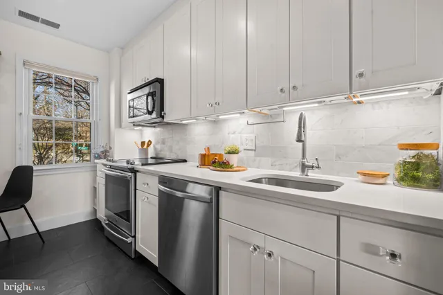 a bathroom with a granite countertop toilet sink and mirror