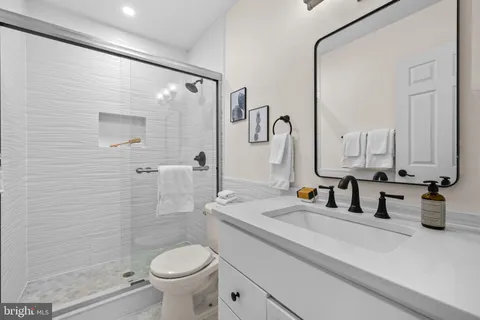 a bathroom with a double vanity sink toilet and shower