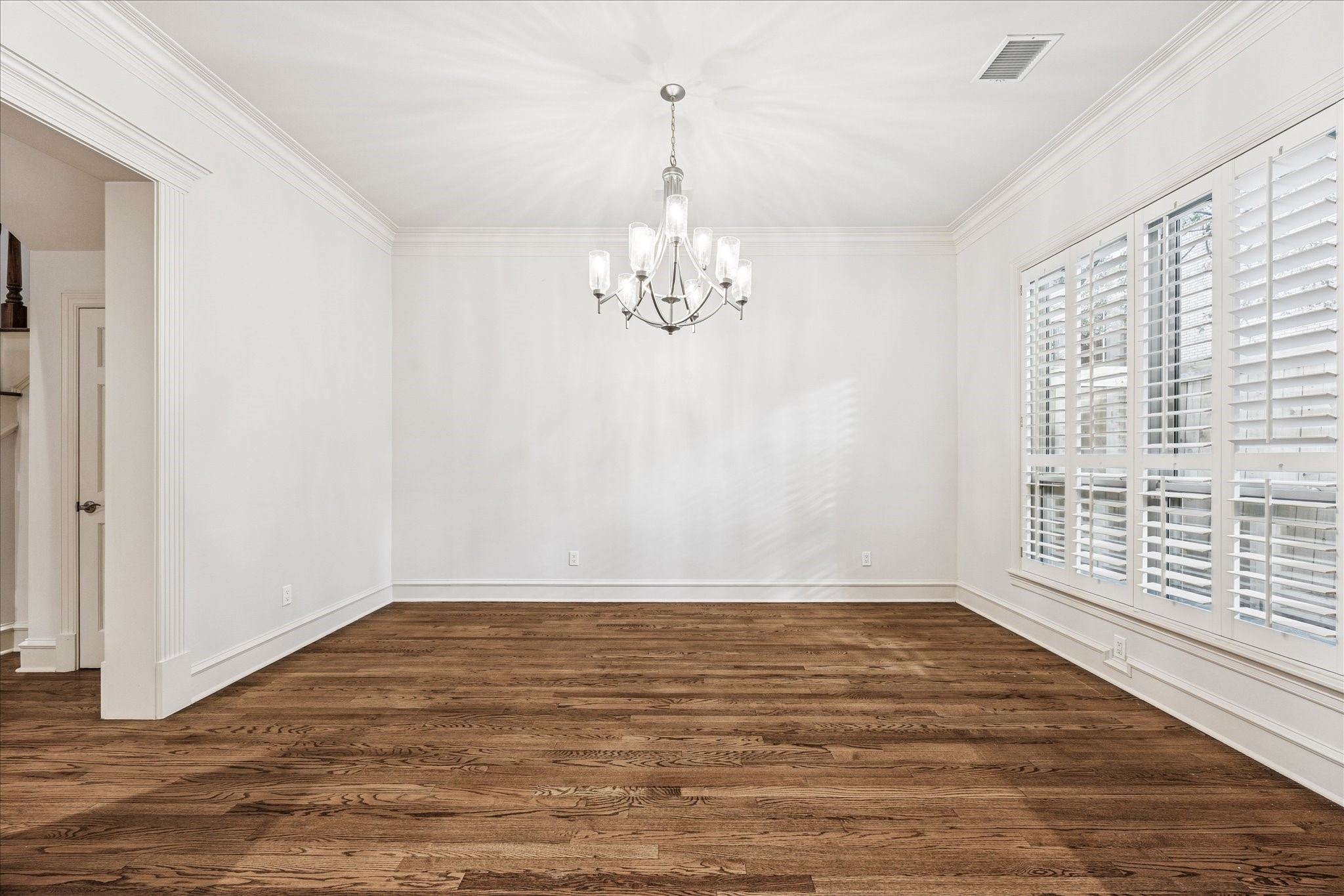 5823 Augusta Court Houston, TX 77057 - Photo 10 of 44 The dining room with elegant hardwood floors, a modern chandelier, and large windows with plantation shutters for ample natural light. Ideal for entertaining.