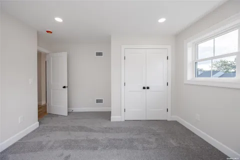 an empty room with windows and closet
