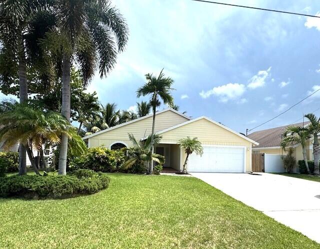 6362 Barbara Street Jupiter, FL 33458 - Photo 1 of 20 a front view of a house with garden