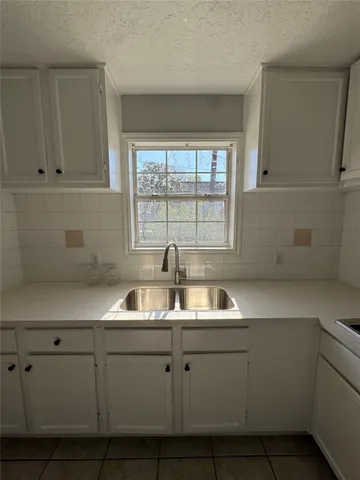 a kitchen with white cabinets and a sink