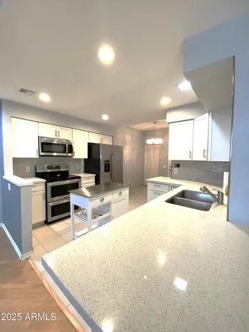 a kitchen with stainless steel appliances a stove a microwave a sink and a refrigerator