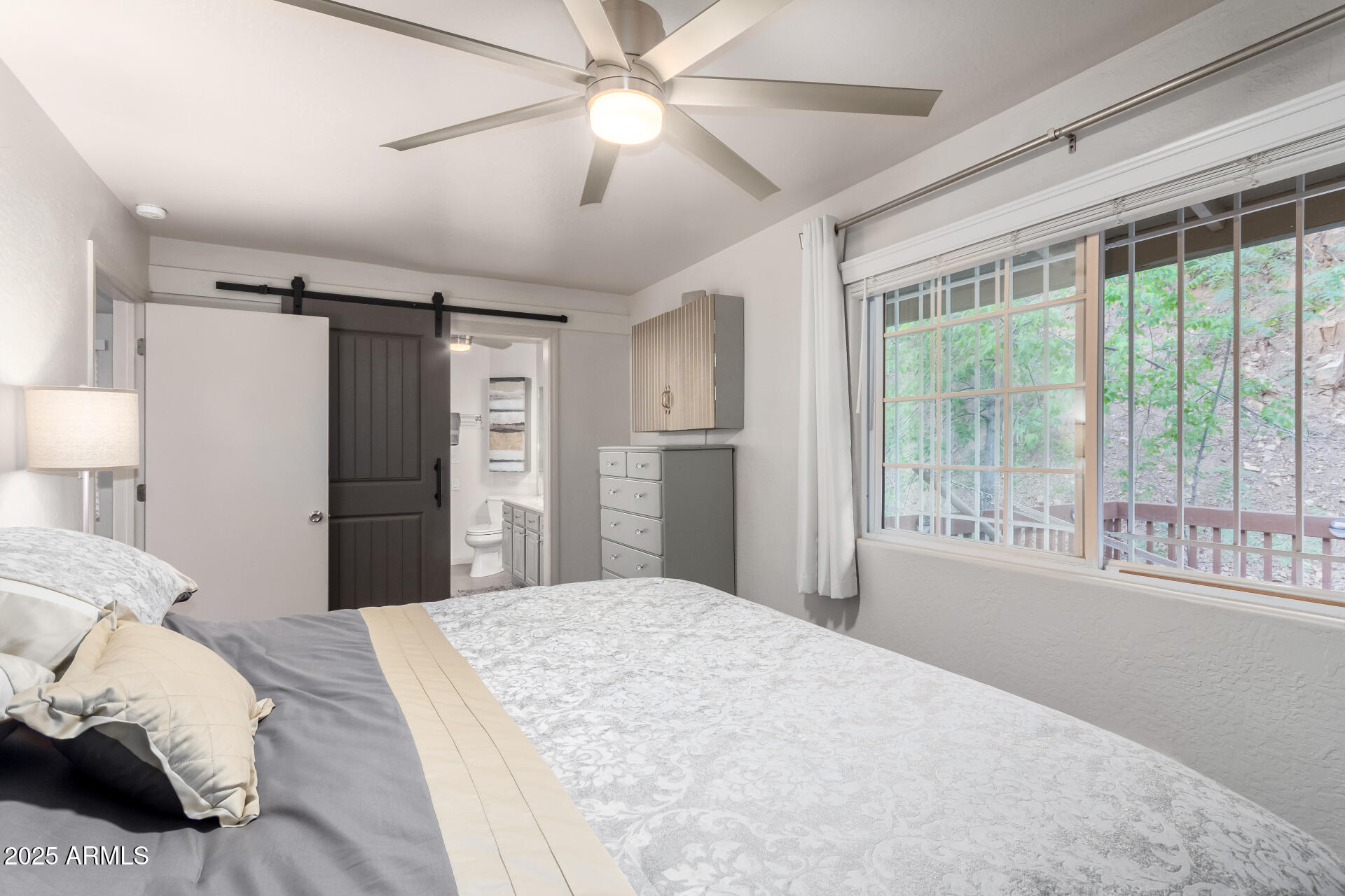 8475 South Breezy Pine Road Mayer, AZ 86333 - Photo 19 of 43 a bedroom with a large bed and a chandelier