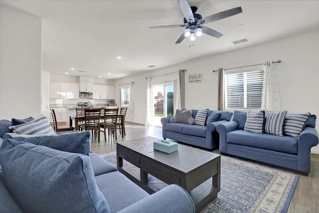a living room with furniture a ceiling fan and a window