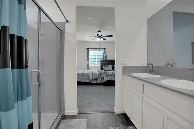 a en suite bathroom with a double vanity sink a mirror and a shower