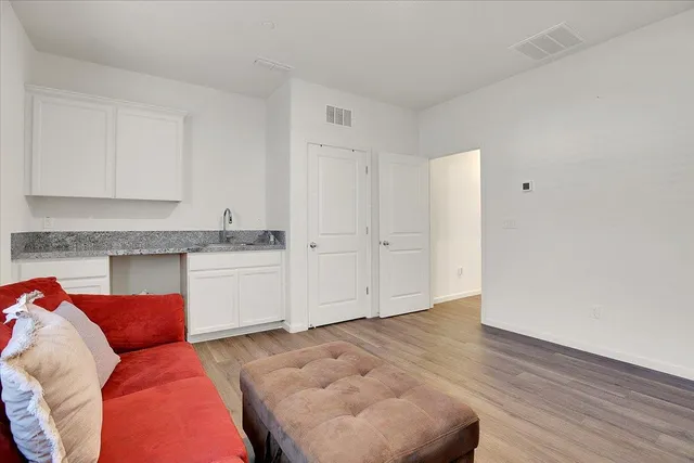 a living room with furniture and a wooden floor