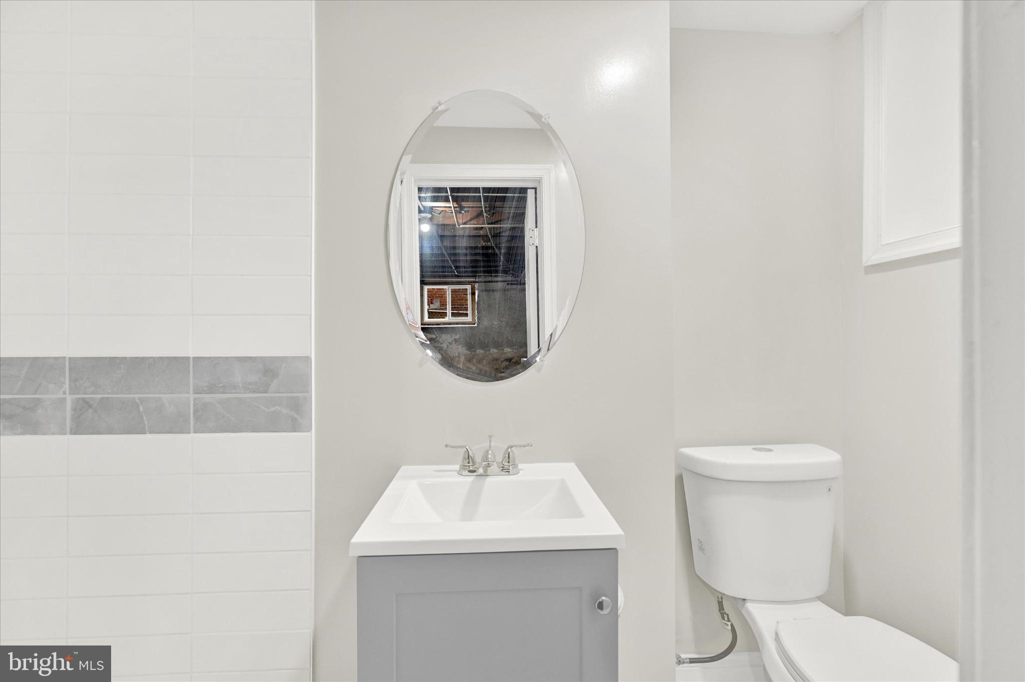3940 Penhurst Avenue Baltimore, MD 21215 - Photo 20 of 24 a bathroom with a toilet sink and mirror
