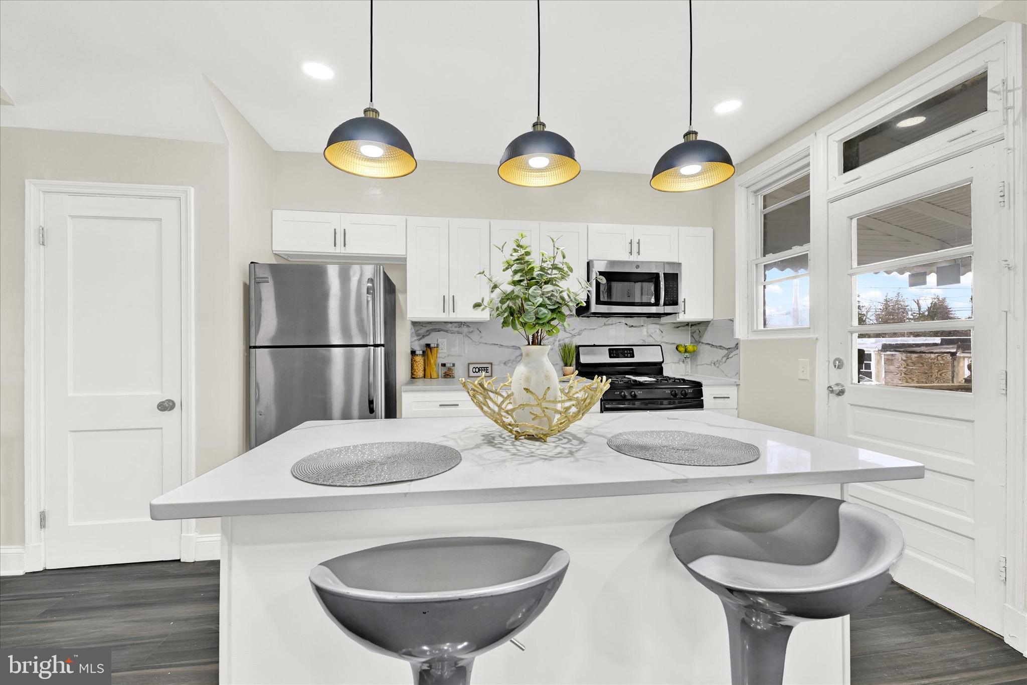 3940 Penhurst Avenue Baltimore, MD 21215 - Photo 8 of 24 a kitchen with stainless steel appliances granite countertop a sink and a refrigerator