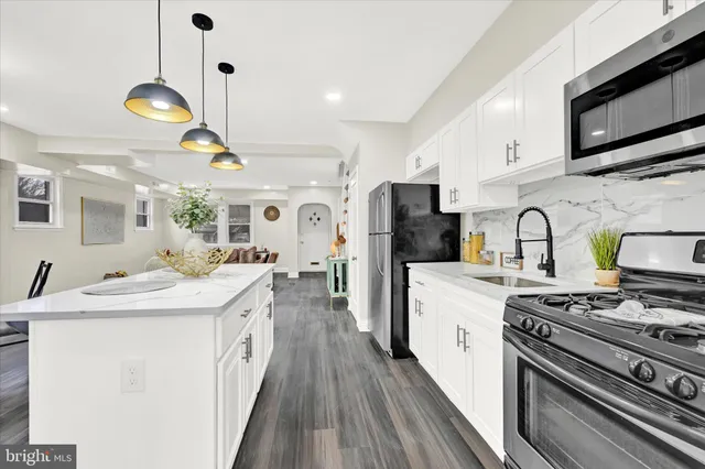 a large kitchen with stainless steel appliances granite countertop a lot of counter space and wooden floors