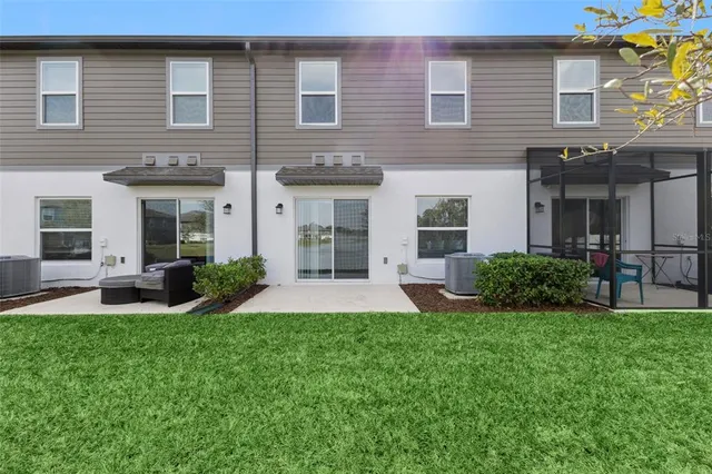 a view of a house with a yard and chairs