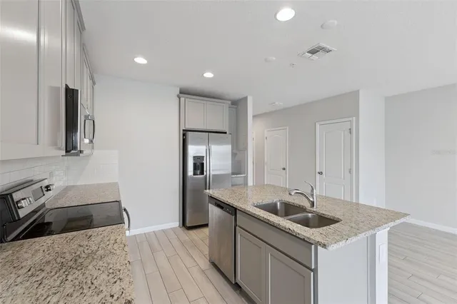 a kitchen that has a sink a stove and a refrigerator