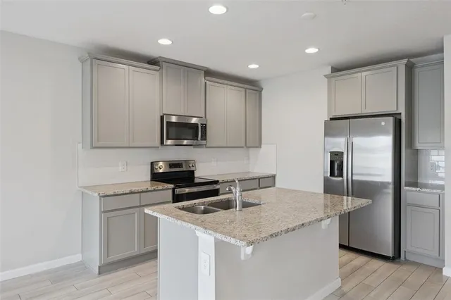 a kitchen with a sink a microwave a refrigerator and cabinets
