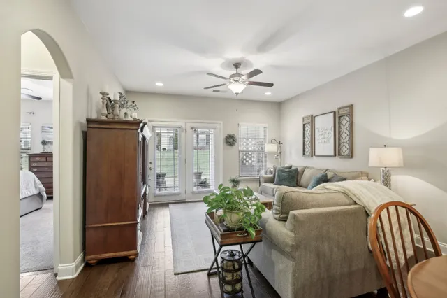 a living room with furniture a large window and wooden floor