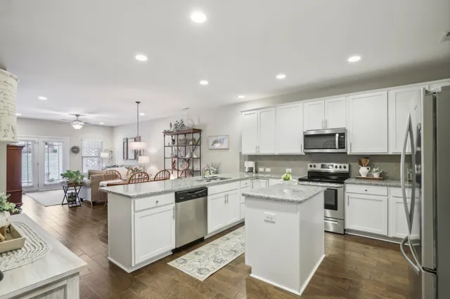 a kitchen with granite countertop white cabinets and stainless steel appliances
