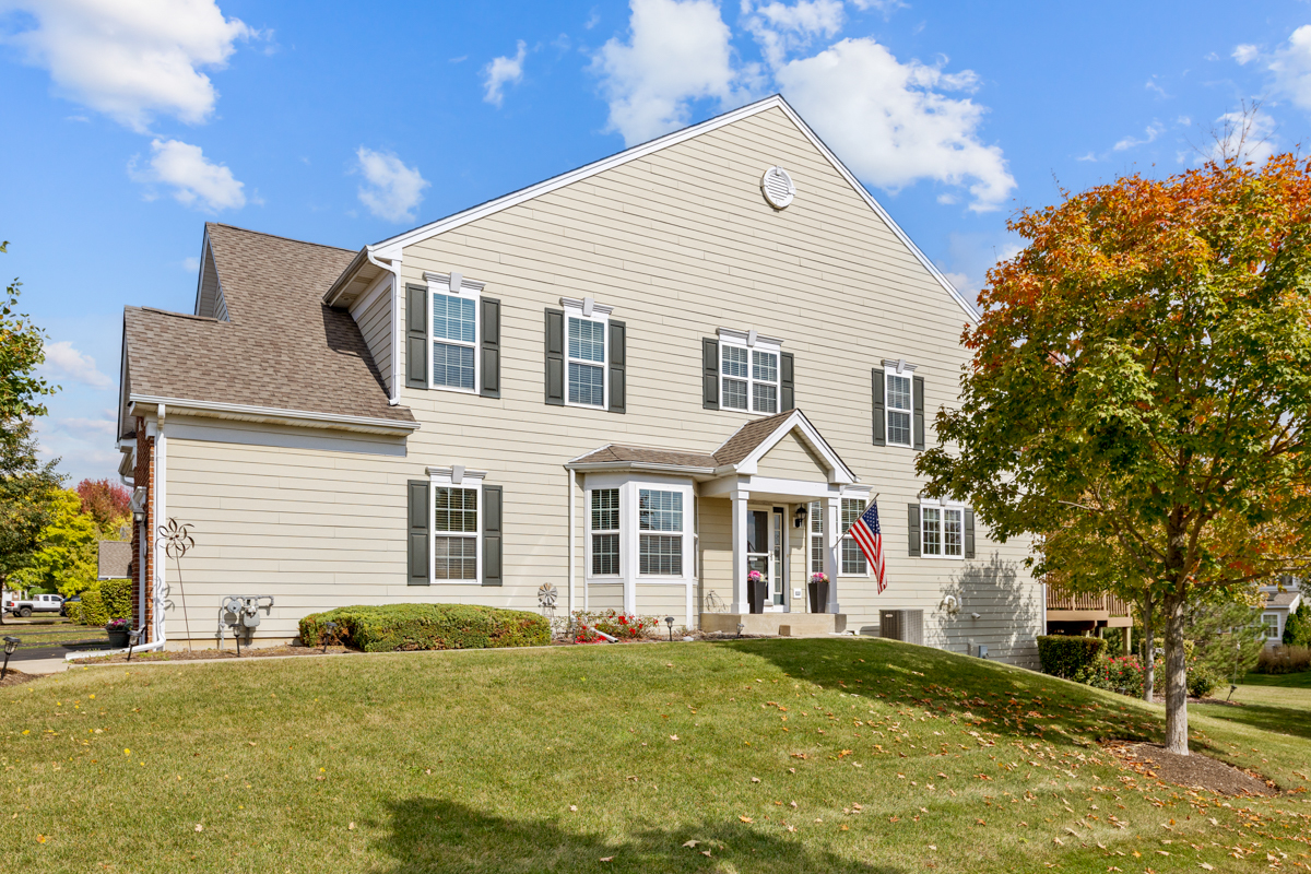 1127 Pine Valley Court Elgin, IL 60124 - Photo 1 of 27 a view of a white house next to a yard with plants and large trees