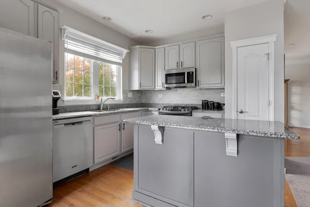 a kitchen with appliances a sink and a window
