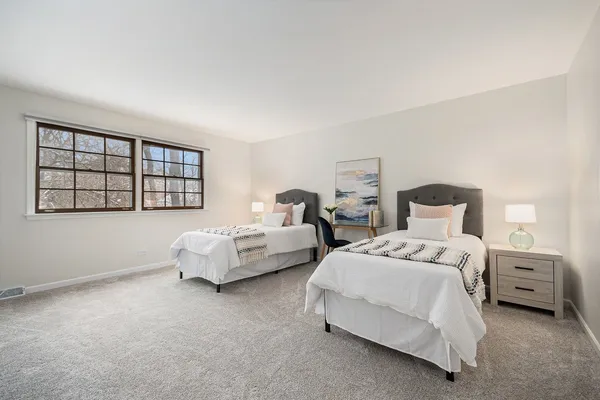 a spacious bedroom with two beds and painting on the wall