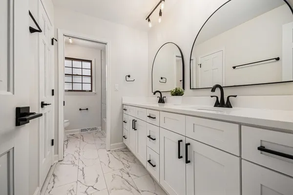 a bathroom with a double vanity sink a mirror and shower
