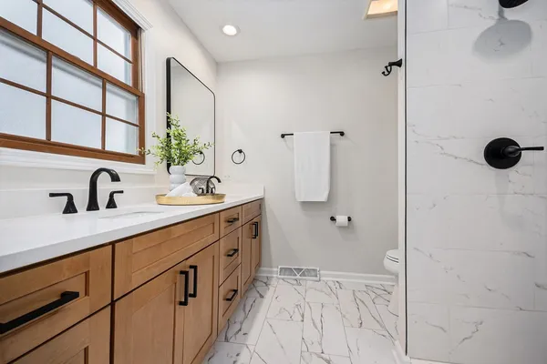 a bathroom with a double vanity sink a mirror and shower