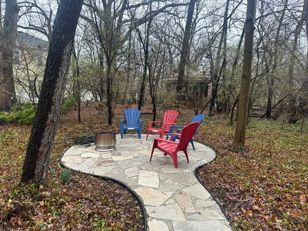 a view of a chairs and fire pit in the backyard
