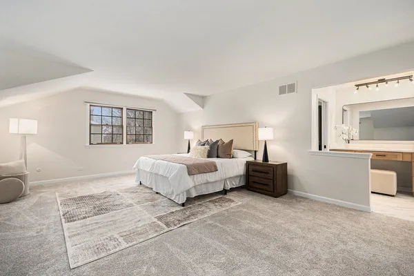 a spacious bedroom with a bed and a couch