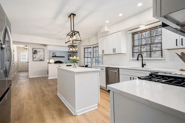 a kitchen that has a lot of cabinets in it and wooden floors