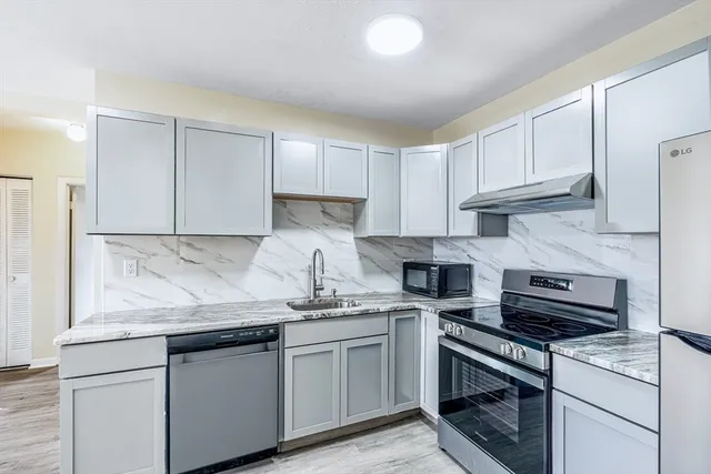 a kitchen with stainless steel appliances granite countertop a sink stove and cabinets