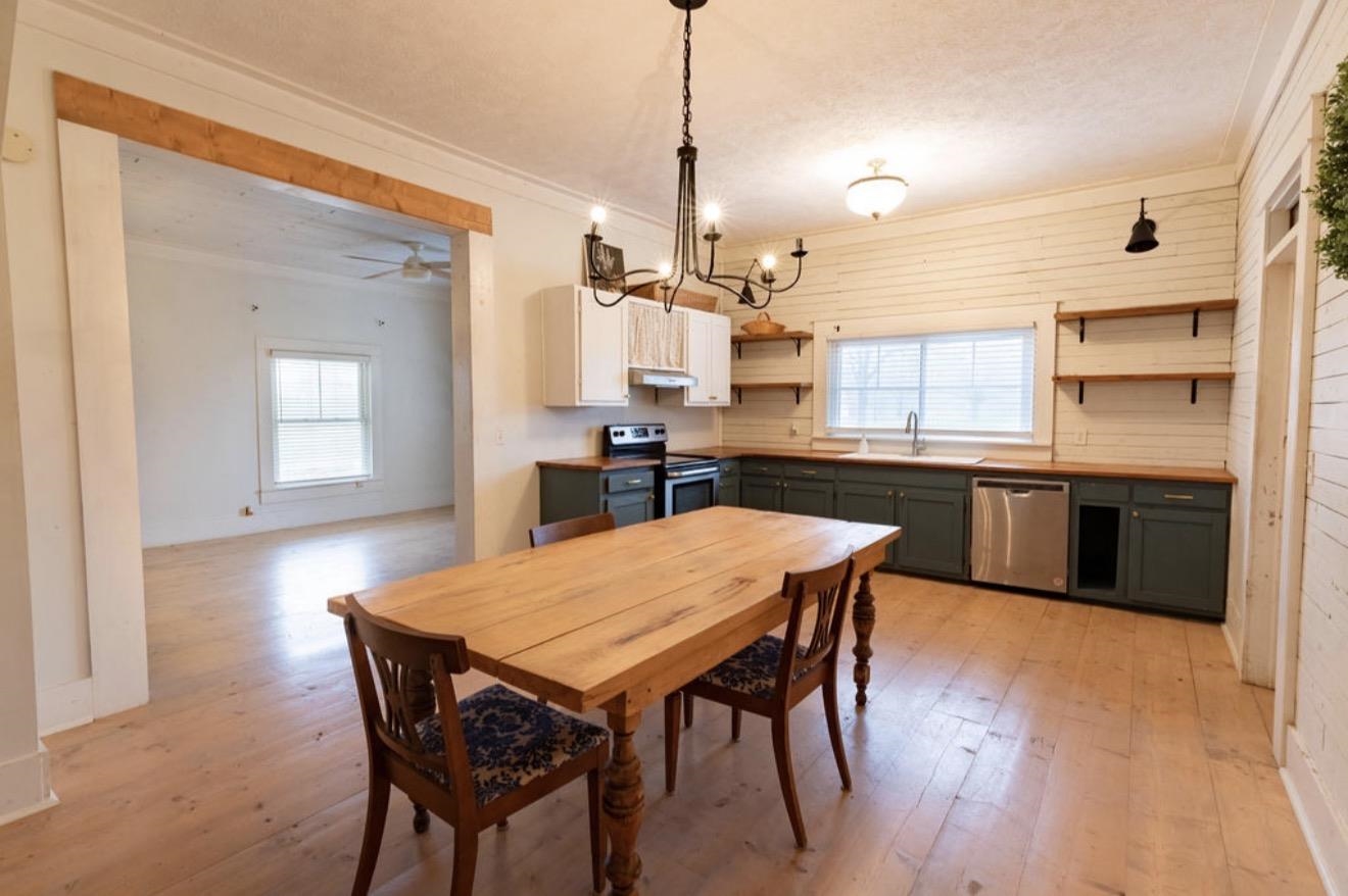 160 Chewalla Road Ramer, TN 38367 - Photo 12 of 39 Dining room featuring ornamental molding, light wood finished floors, hanging lights, and wooden walls