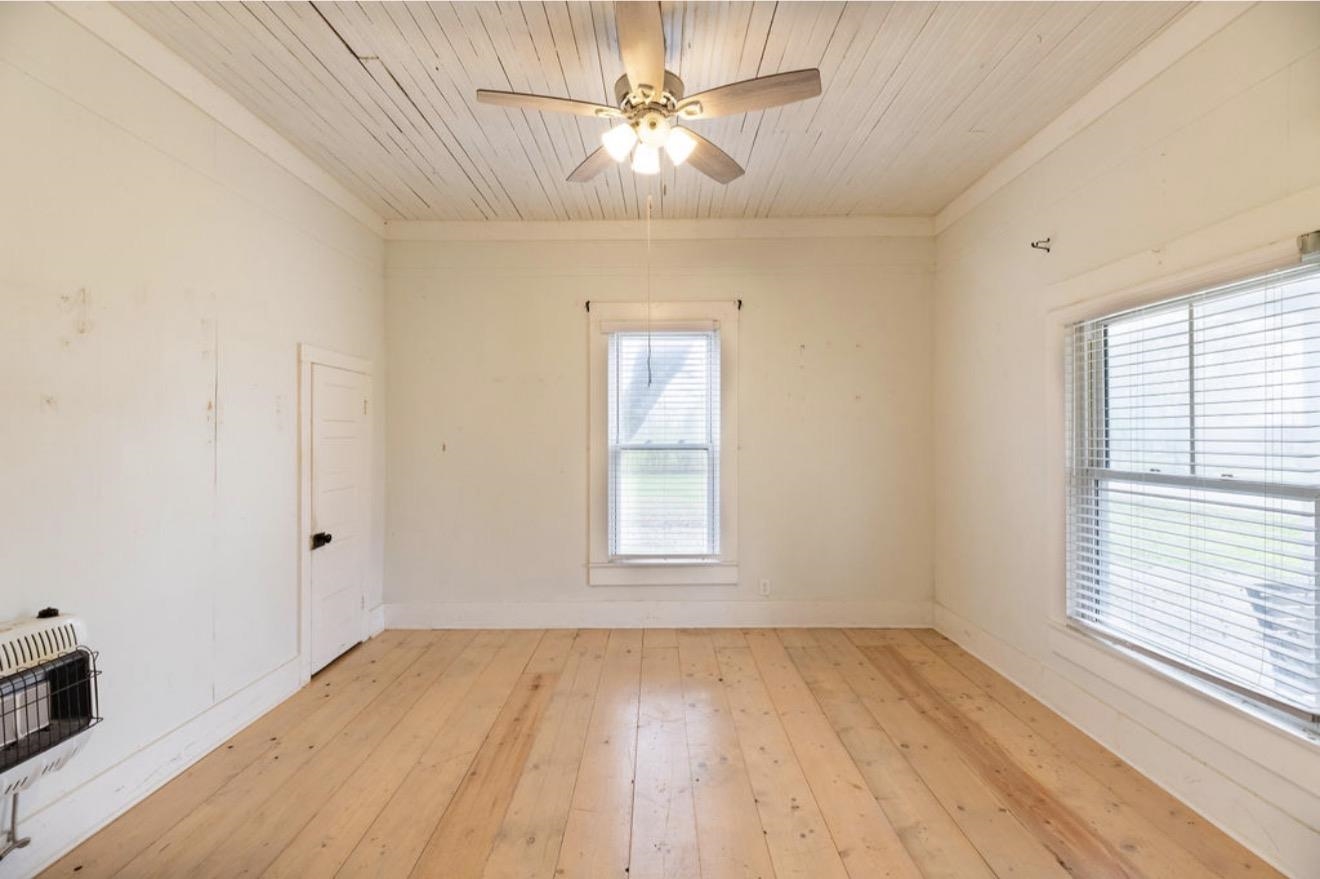 160 Chewalla Road Ramer, TN 38367 - Photo 19 of 39 Empty room with light wood-type flooring, ceiling fan, wooden ceiling, heating unit, and ornamental molding