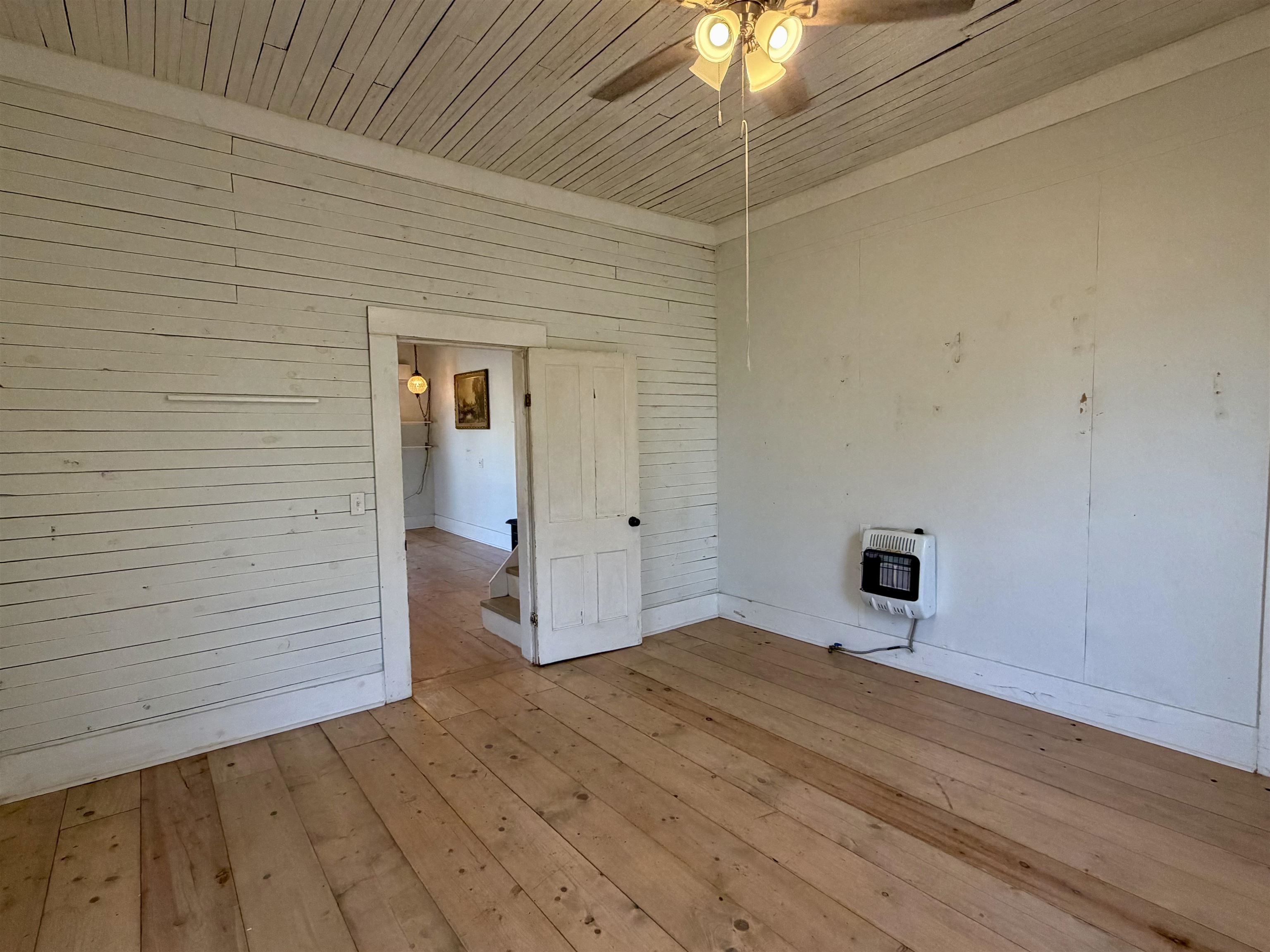160 Chewalla Road Ramer, TN 38367 - Photo 20 of 39 Spare room with hardwood / wood-style floors, wood ceiling, a ceiling fan, heating unit, and wood walls