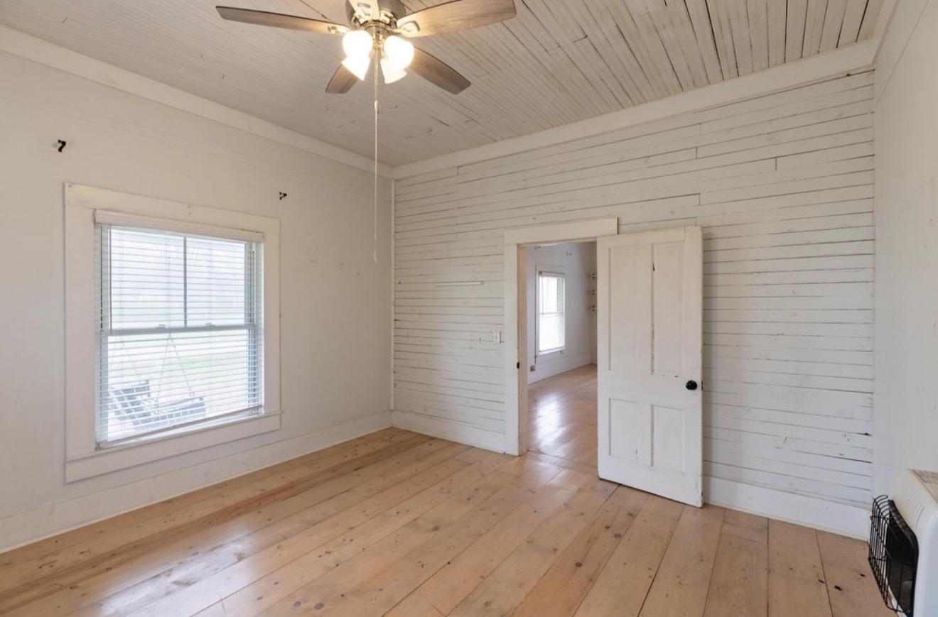 160 Chewalla Road Ramer, TN 38367 - Photo 21 of 39 Unfurnished room featuring light wood finished floors, wooden walls, wood ceiling, a ceiling fan, and heating unit