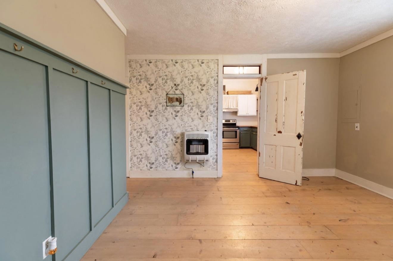 160 Chewalla Road Ramer, TN 38367 - Photo 27 of 39 Unfurnished living room featuring light wood-style floors, heating unit, a textured ceiling, and electric panel