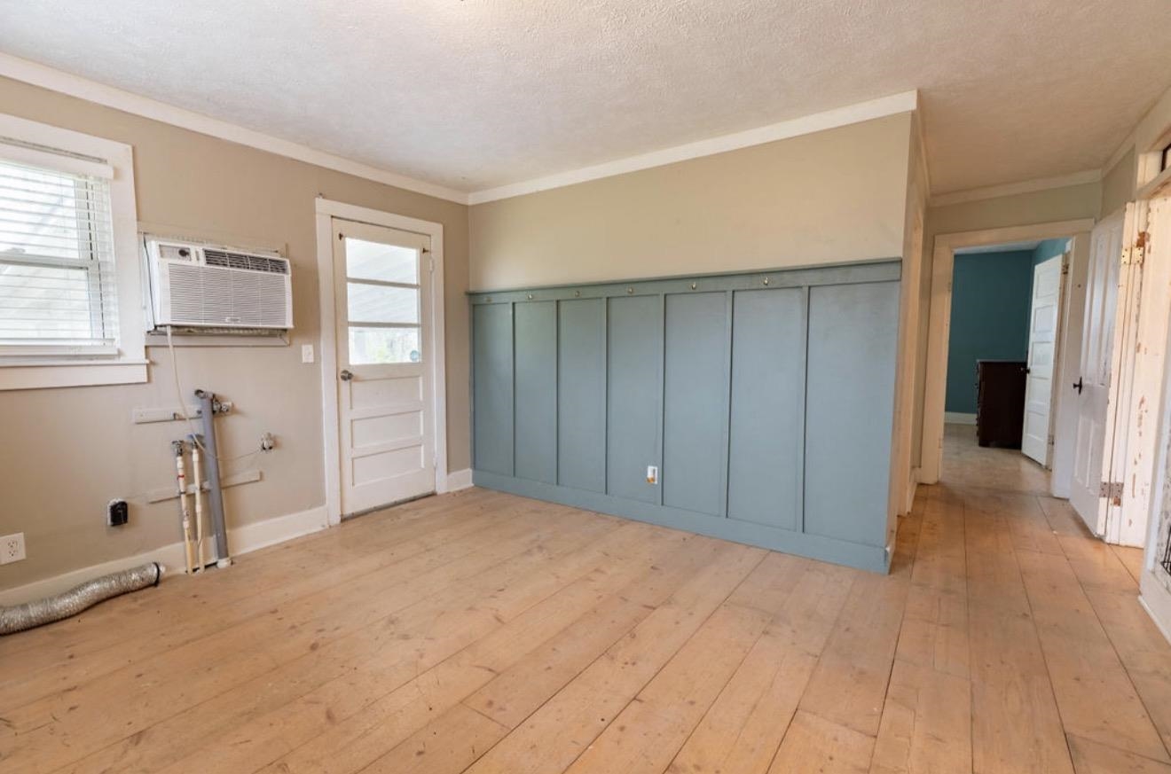 160 Chewalla Road Ramer, TN 38367 - Photo 28 of 39 Unfurnished dining area with light wood-style floors, ornamental molding, a textured ceiling, and wainscoting