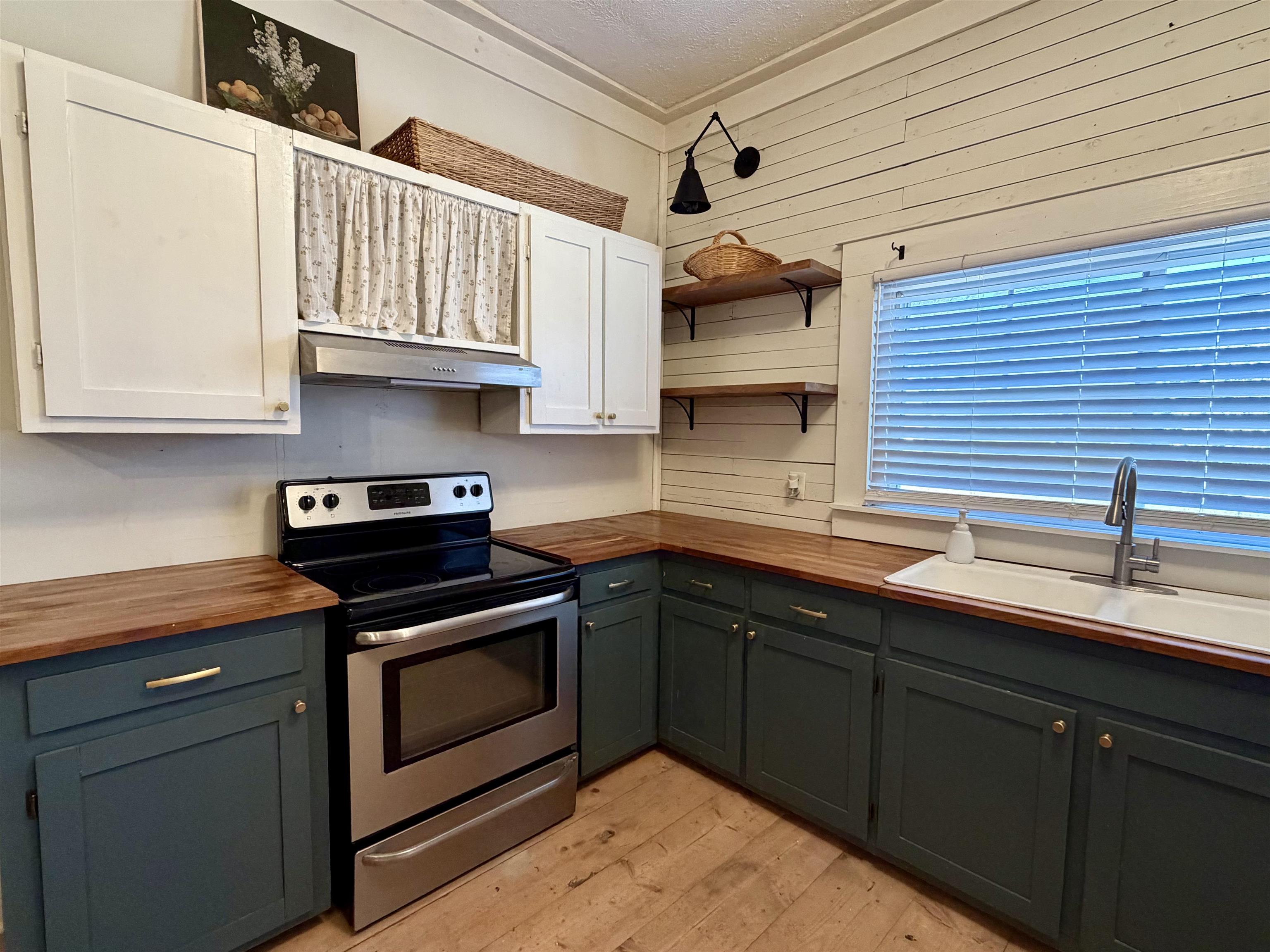 160 Chewalla Road Ramer, TN 38367 - Photo 9 of 39 Kitchen featuring butcher block counters, stainless steel electric stove, light wood finished floors, dual tone cabinetry, and open shelves