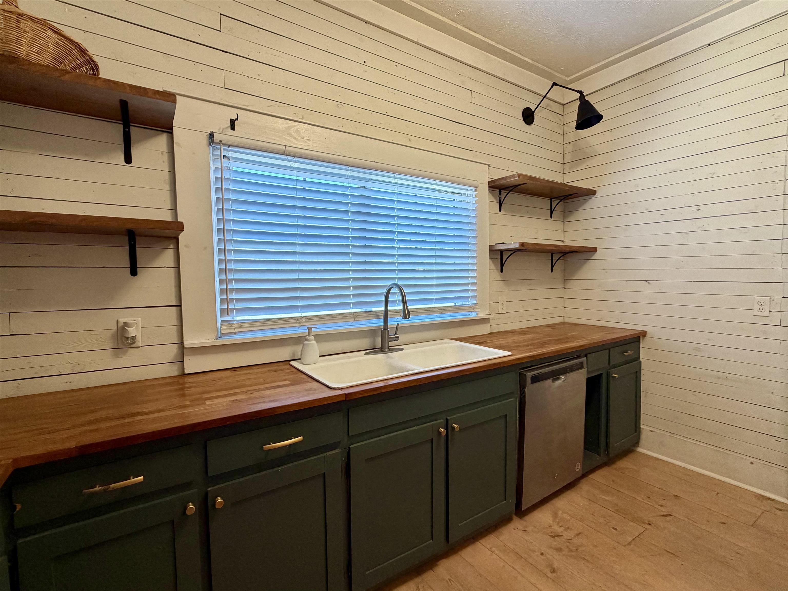 160 Chewalla Road Ramer, TN 38367 - Photo 10 of 39 Kitchen featuring wooden counters, open shelves, wood walls, stainless steel dishwasher, and green cabinetry