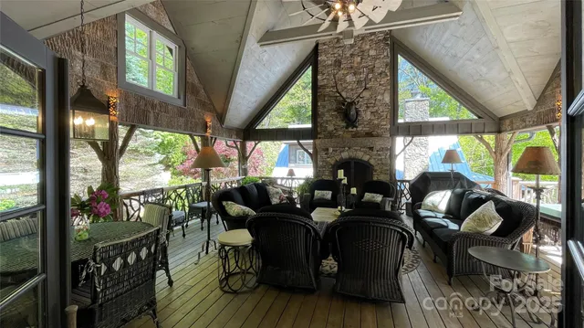 a living room with furniture fireplace and large windows