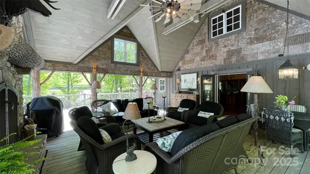 a living room with furniture a fireplace and a floor to ceiling window
